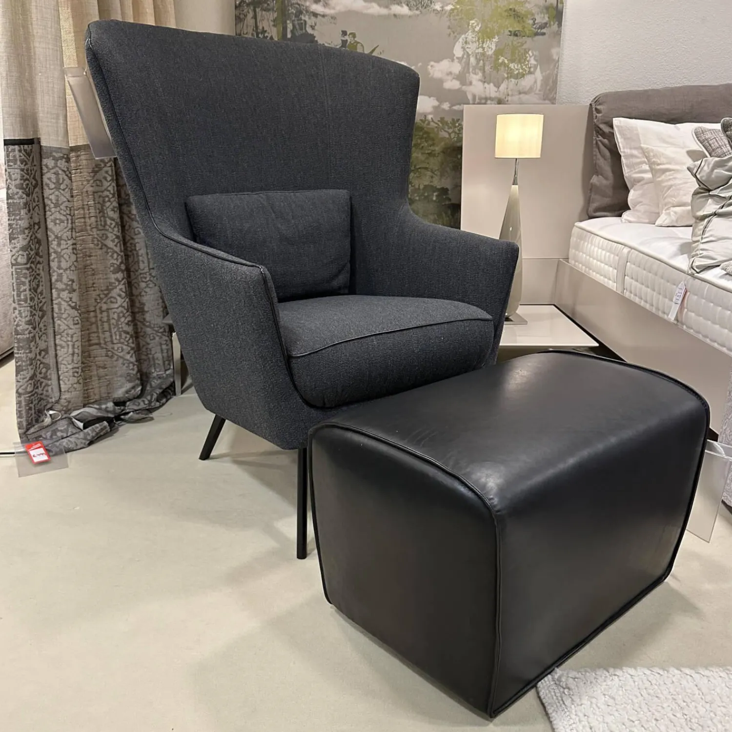 Christine Kröncke Relaxsessel|Hochlehnsessel Lilou Stoff Rye Schwarzgrau Fuß Schwarz mit Hocker Derby